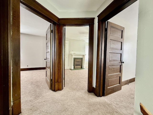 corridor with baseboards and carpet flooring