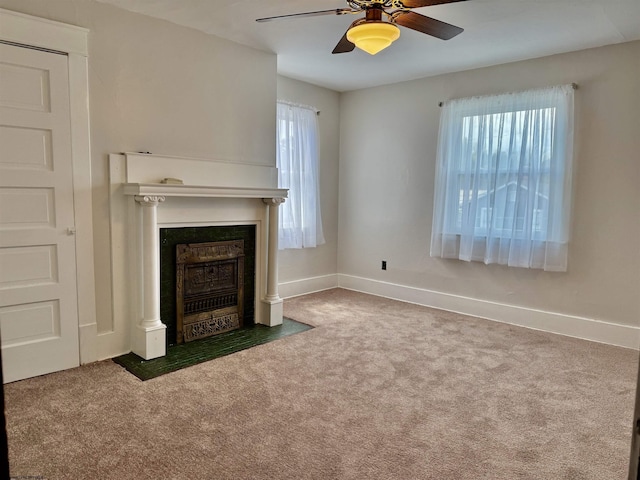 unfurnished living room with a fireplace with flush hearth, baseboards, carpet floors, and ceiling fan