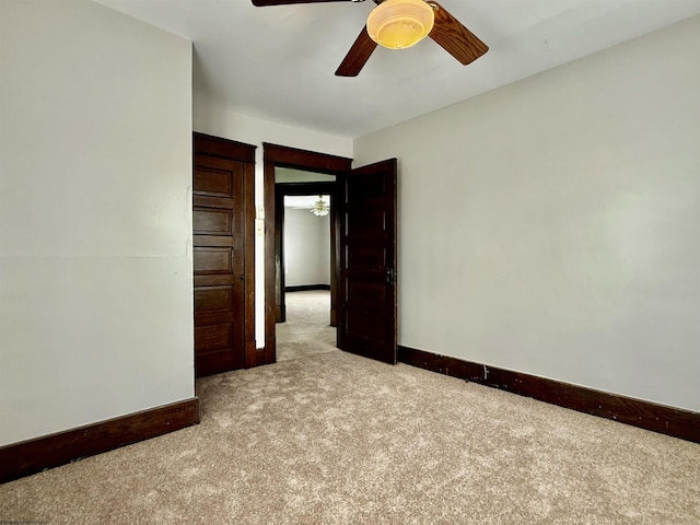 spare room featuring carpet flooring, baseboards, and a ceiling fan