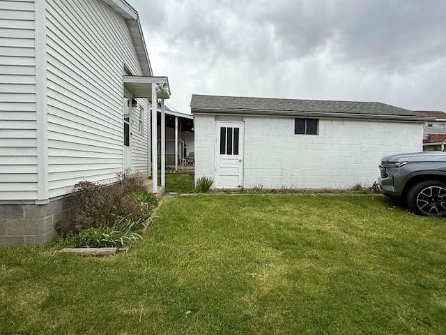 view of side of home with a yard and concrete block siding