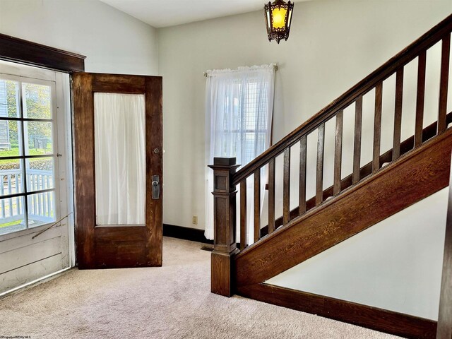 entrance foyer featuring carpet floors and stairway