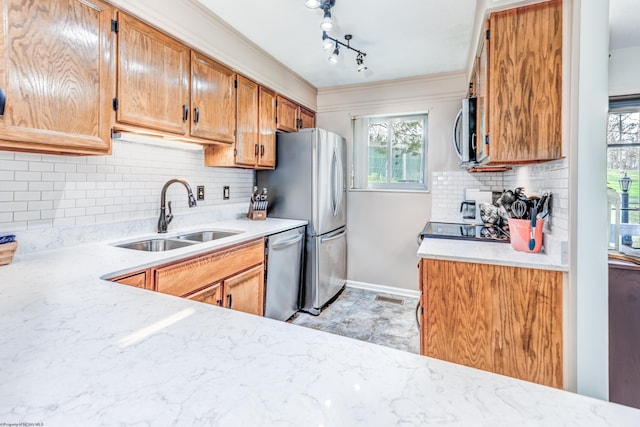 kitchen featuring ornamental molding, a sink, baseboards, tasteful backsplash, and appliances with stainless steel finishes