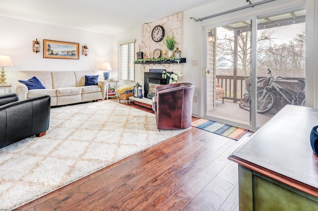 living area featuring a stone fireplace and wood finished floors