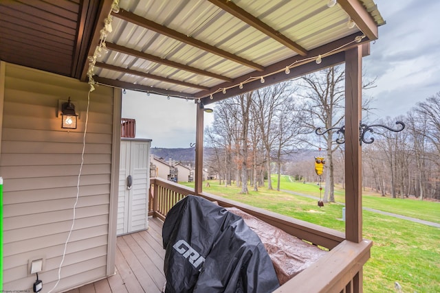 wooden deck featuring grilling area and a yard