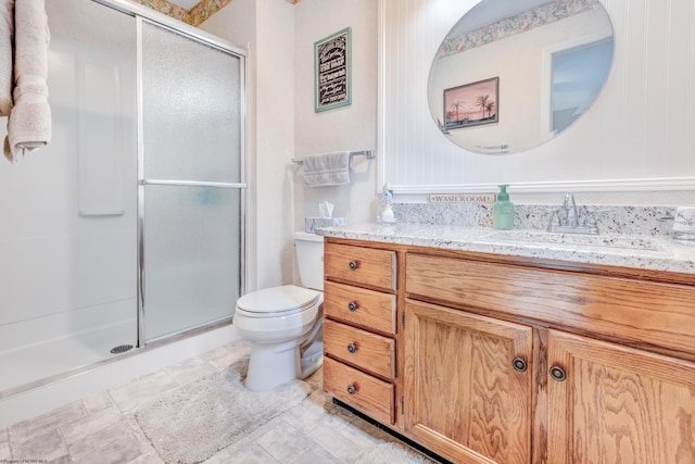 full bathroom featuring a shower stall, toilet, and vanity
