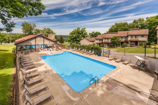 pool with a yard, a patio, and fence