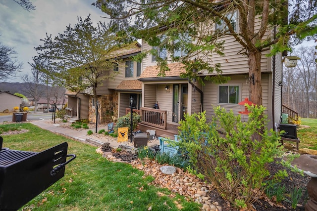 view of front of house featuring a wooden deck and a front yard