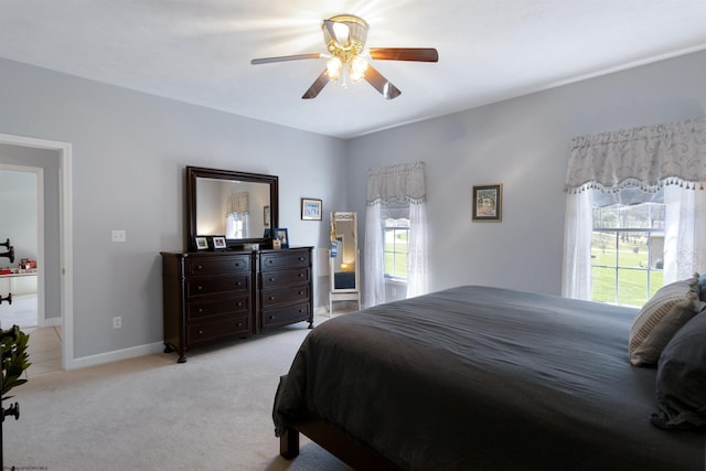 bedroom with light carpet, baseboards, and ceiling fan