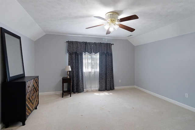 unfurnished bedroom with visible vents, vaulted ceiling, baseboards, and light colored carpet