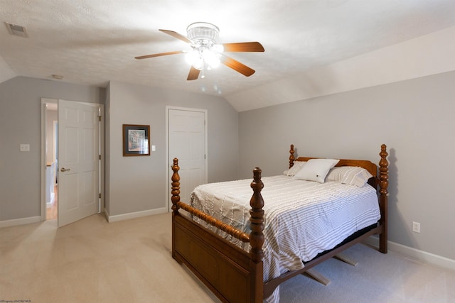 bedroom with lofted ceiling, light carpet, baseboards, and visible vents
