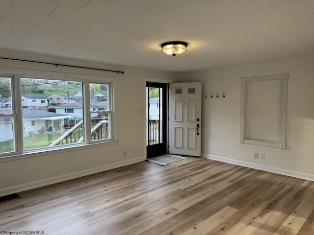 foyer with baseboards, visible vents, and light wood-style flooring
