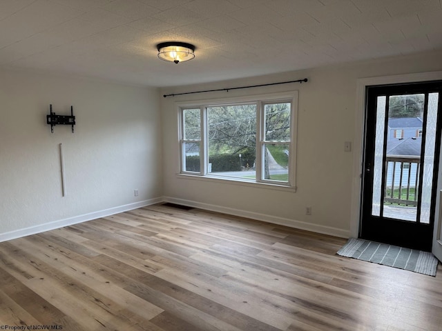 unfurnished dining area featuring light wood-style flooring, baseboards, and a healthy amount of sunlight
