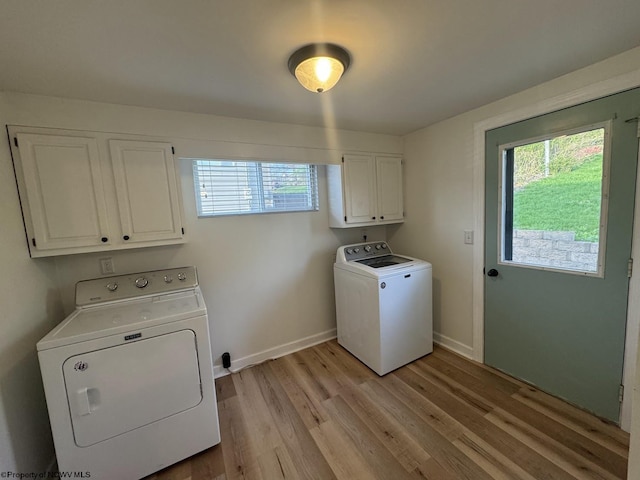 laundry area with baseboards, cabinet space, washer and clothes dryer, and light wood-style flooring