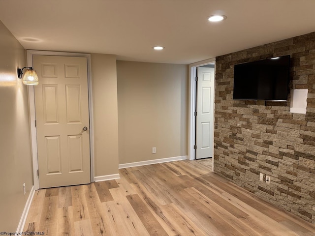 finished below grade area with recessed lighting, light wood-style floors, and baseboards