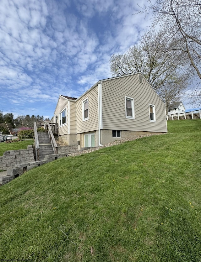 view of side of home featuring a lawn and stairs