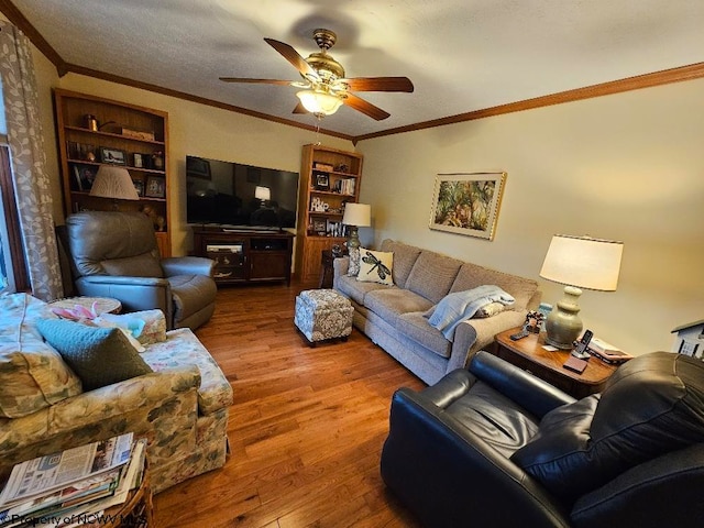 living room with wood finished floors, built in features, ceiling fan, and crown molding