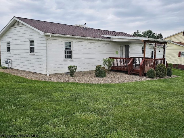 back of property with a wooden deck and a yard