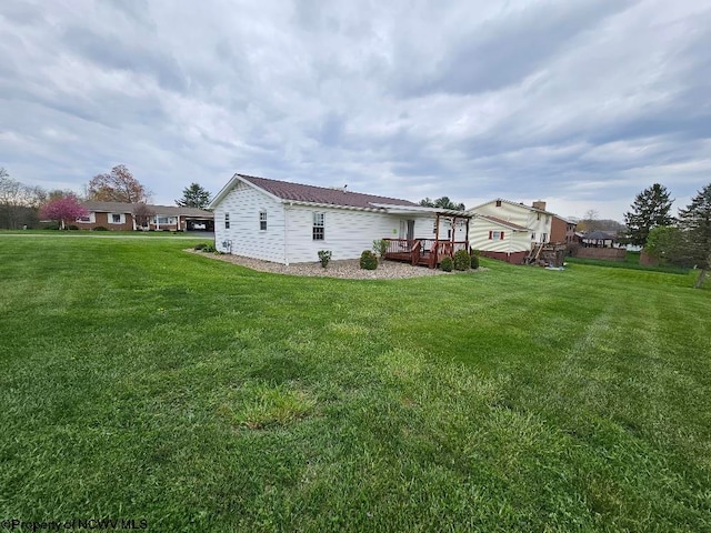 view of side of home with a lawn and a deck