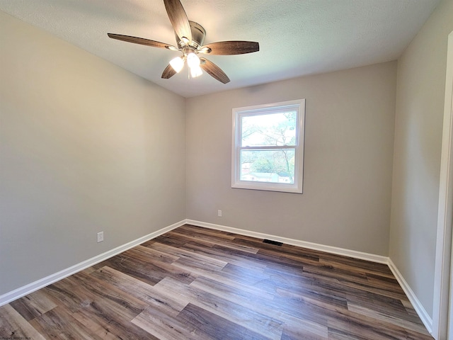 unfurnished room featuring baseboards, a textured ceiling, dark wood-type flooring, and ceiling fan