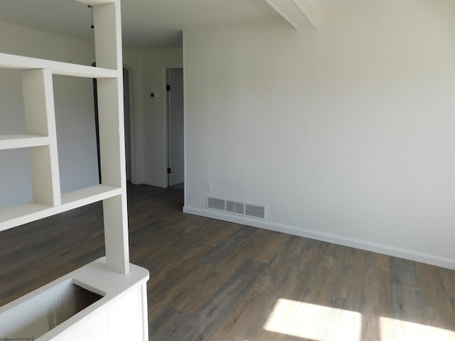 interior space with baseboards, dark wood-type flooring, and visible vents