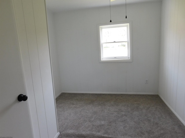 carpeted spare room with baseboards