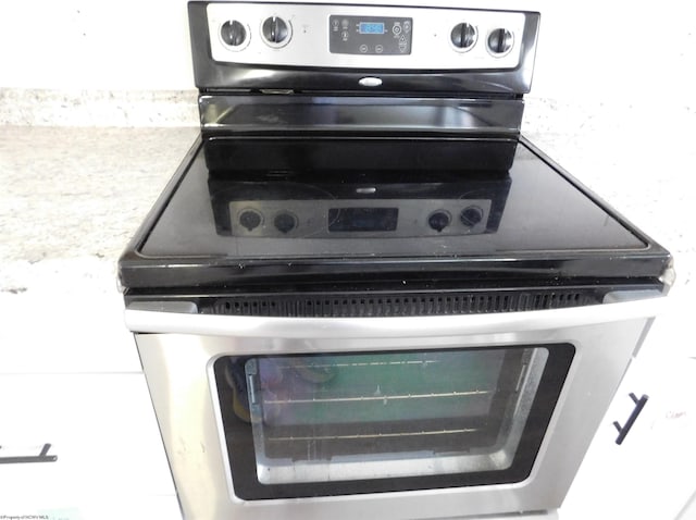 details with stainless steel electric stove and light countertops