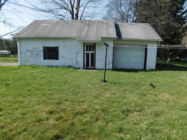 view of front of home with a garage, roof with shingles, and a front lawn