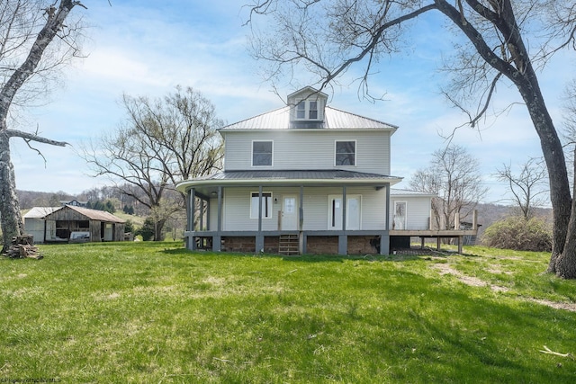 back of house with a porch, a yard, and metal roof