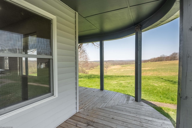 wooden deck with a lawn and a rural view