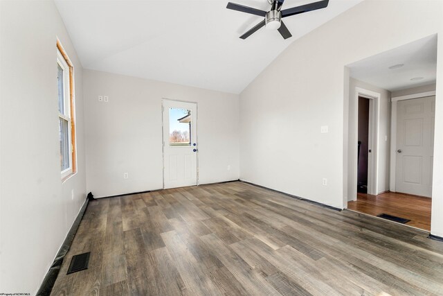 empty room featuring lofted ceiling, a ceiling fan, wood finished floors, and visible vents