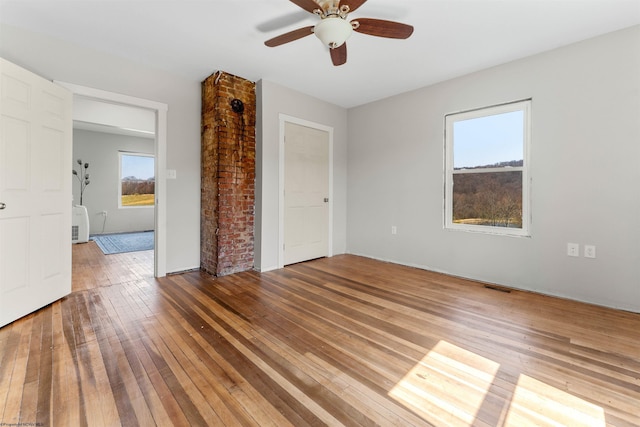 unfurnished room featuring visible vents, ceiling fan, and wood-type flooring