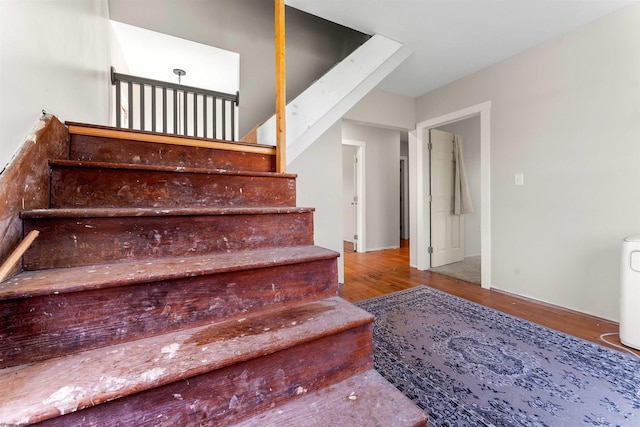 stairs featuring wood finished floors