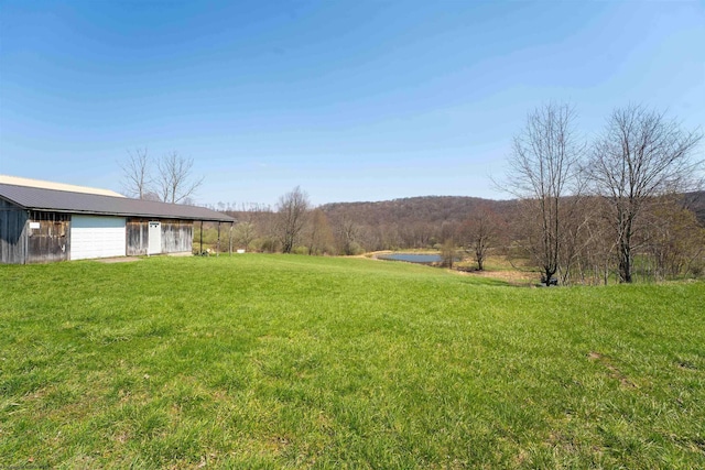 view of yard with a detached garage and a water view