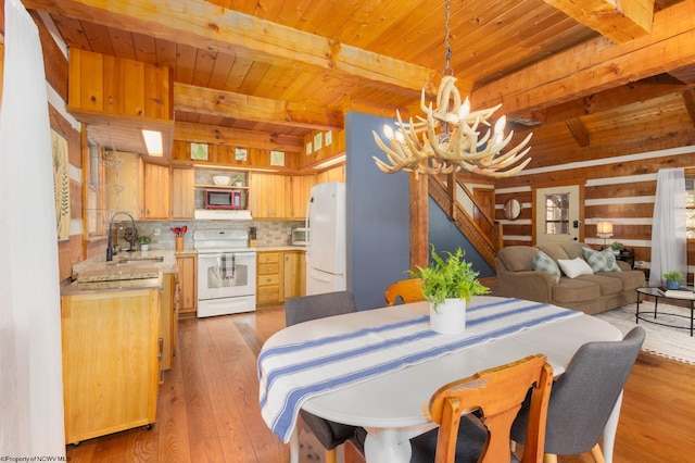 dining area with wood ceiling, an inviting chandelier, beam ceiling, and light wood-style floors