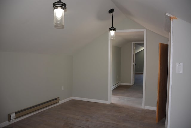 additional living space with baseboards, vaulted ceiling, wood finished floors, and a baseboard radiator