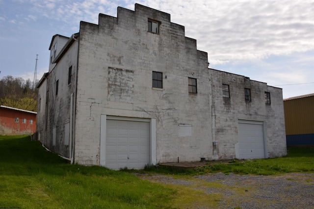 view of property exterior with a yard and an attached garage