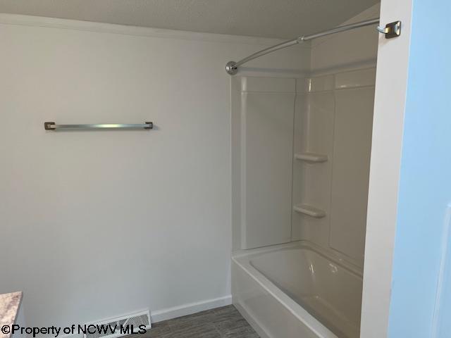full bath with shower / bathing tub combination, baseboards, and wood finished floors