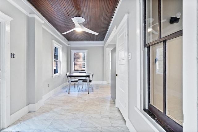 hallway featuring baseboards, marble finish floor, wood ceiling, and ornamental molding