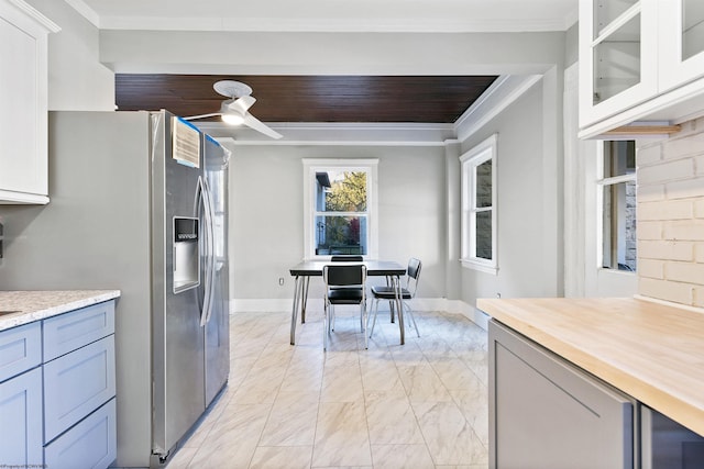kitchen featuring marble finish floor, stainless steel fridge with ice dispenser, ornamental molding, wood counters, and glass insert cabinets