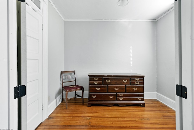 interior space with baseboards, crown molding, and light wood-type flooring