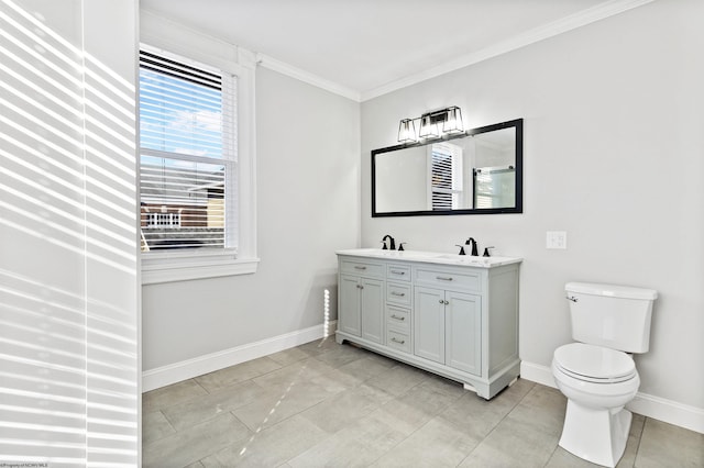bathroom featuring double vanity, toilet, ornamental molding, a sink, and baseboards