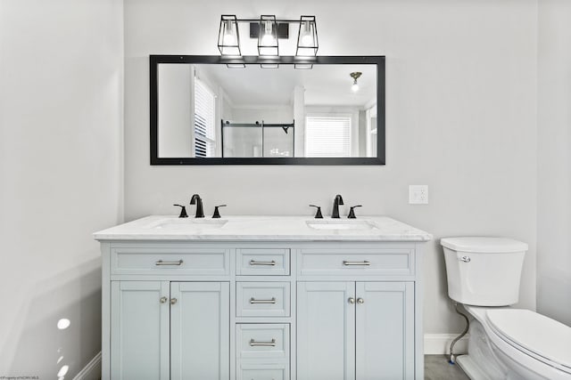 full bath with double vanity, a shower stall, toilet, and a sink