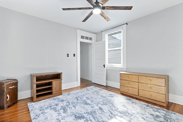 bedroom with wood finished floors, baseboards, and ceiling fan