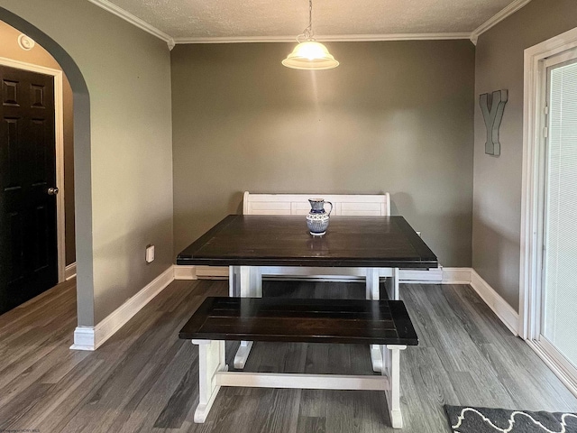 dining area featuring arched walkways, a textured ceiling, dark wood-style flooring, baseboards, and ornamental molding