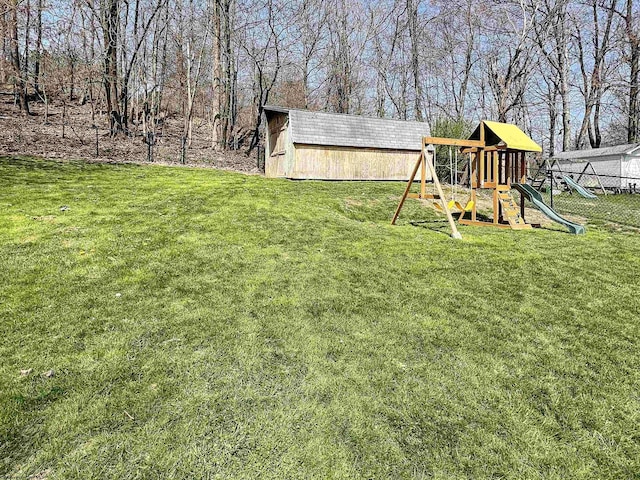 view of yard with fence, an outbuilding, and a playground