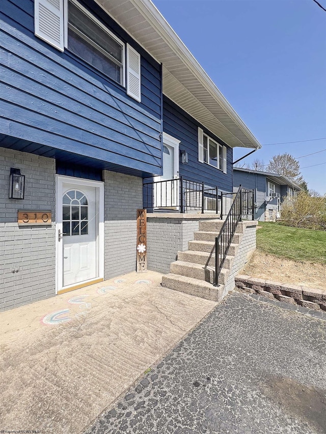 doorway to property featuring brick siding