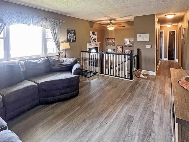 living room featuring a ceiling fan, wood finished floors, and a textured ceiling