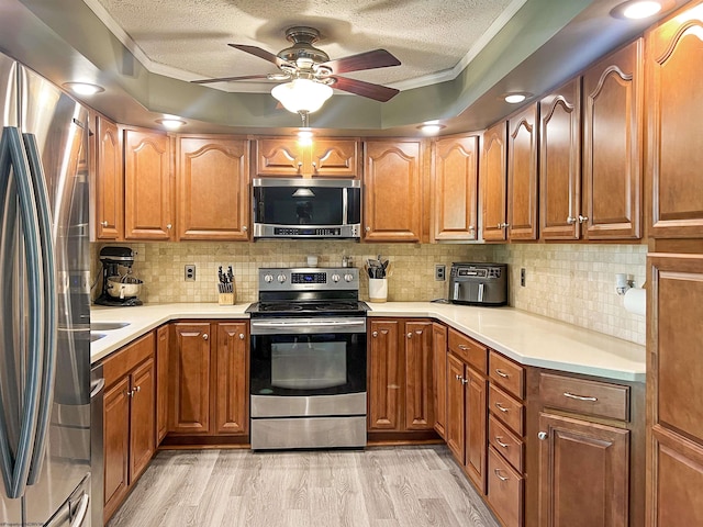 kitchen with light countertops, a ceiling fan, decorative backsplash, a textured ceiling, and appliances with stainless steel finishes
