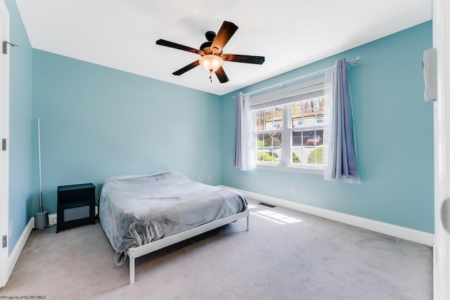 carpeted bedroom featuring baseboards, a ceiling fan, and visible vents