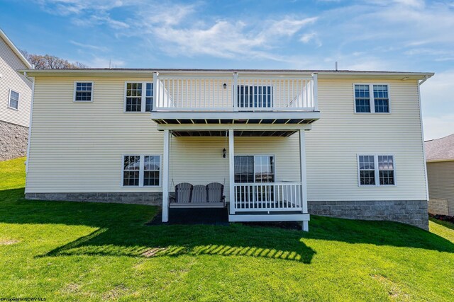 back of property featuring a lawn and a wooden deck